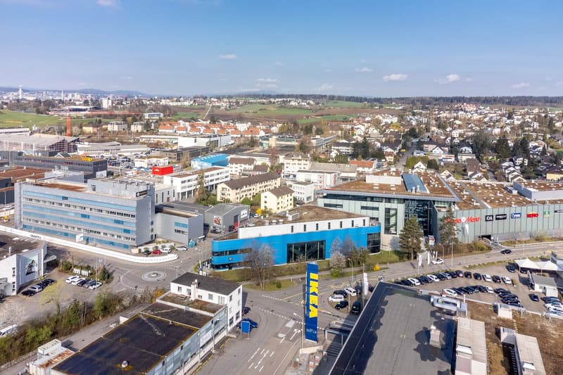 aerial view of commercial buildings, office buildings, residential buildings, parking lots, city skyline, and industrial area
