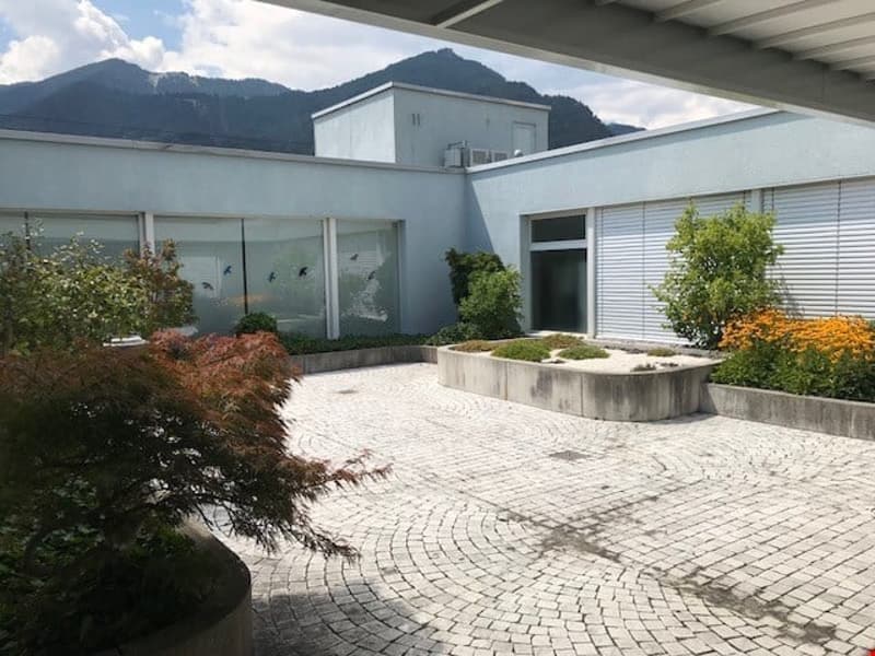 attraktives Atrium im Sommer mit el. Sonnendach für unsere Büro-Mieter