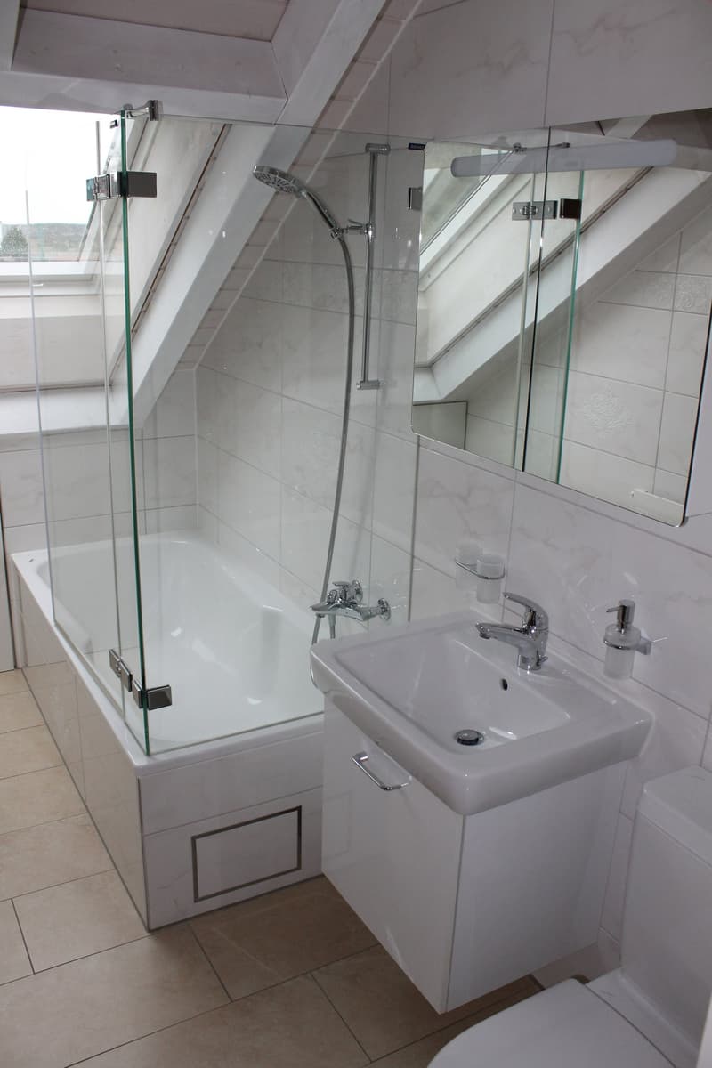 Bathroom with a glass shower, bathtub, white sink, white toilet, and mirror