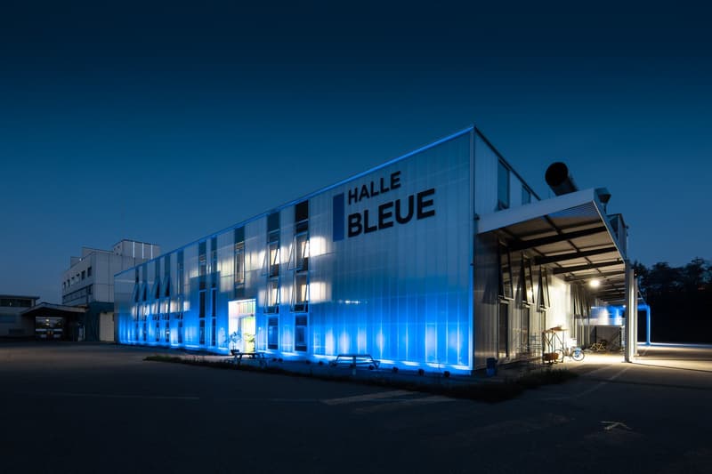 modern building with blue lights, open garage, benches, bicycles