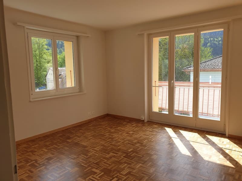 empty room, wooden floor, large windows, doors leading to balcony