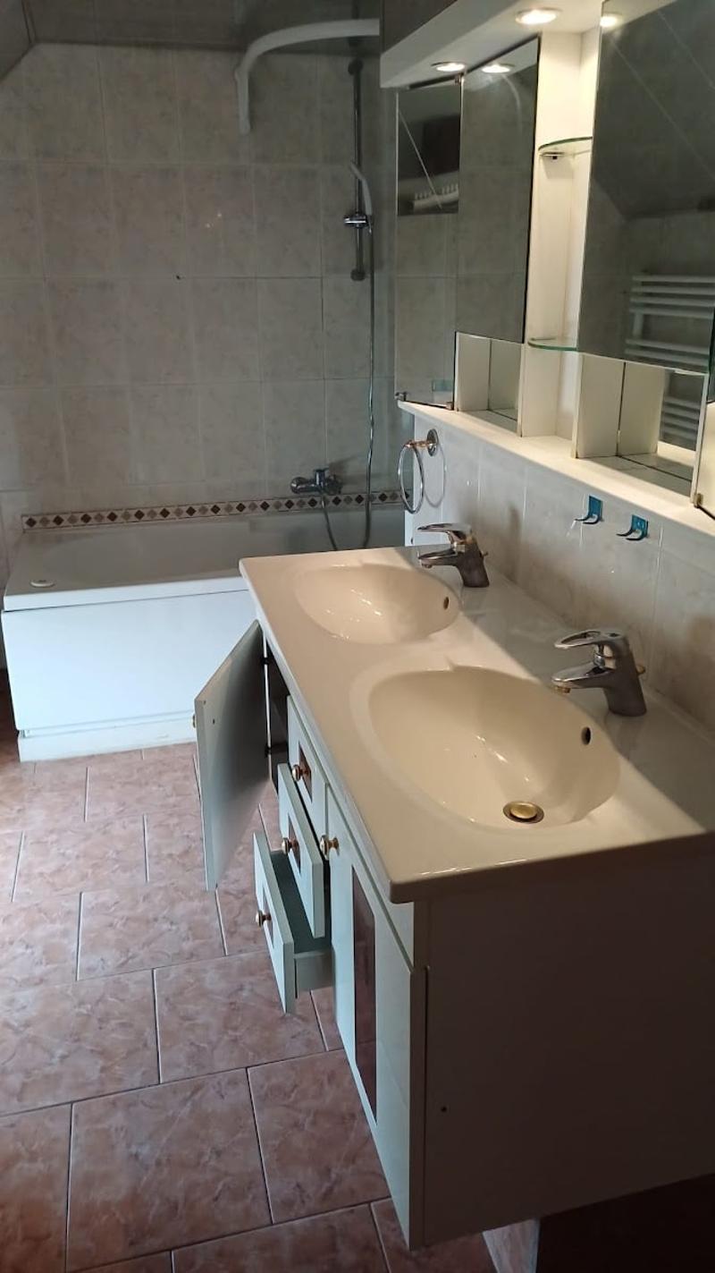 Bathroom with tiled floor, bathtub, two sinks with faucets, and mirrors
