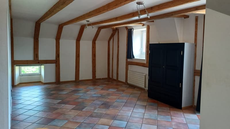 empty room, exposed wooden beams, tiled floor, 2 windows, dark wooden wardrobe