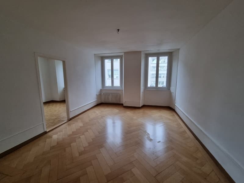 empty room, wooden floor, two windows, white walls, radiator, mirror