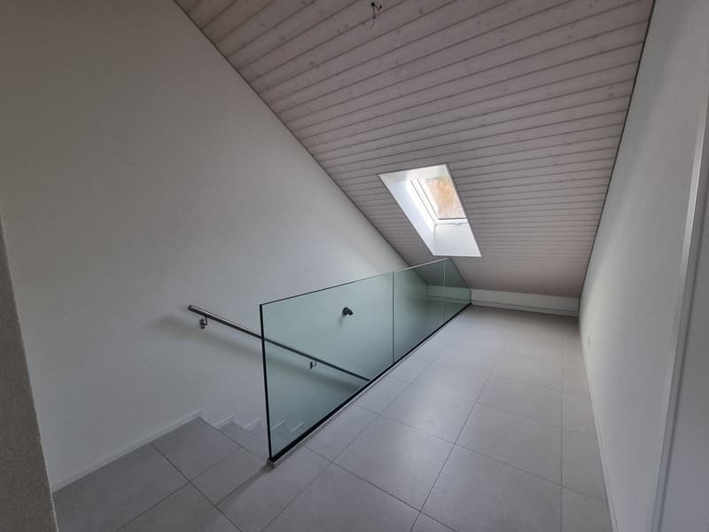 glass staircase, tiled floor, glass railings, sloped ceiling, skylight