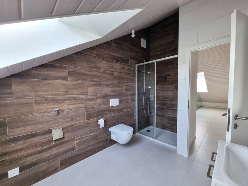 white tile flooring, wooden walls, toilet, glass walk-in shower, sink