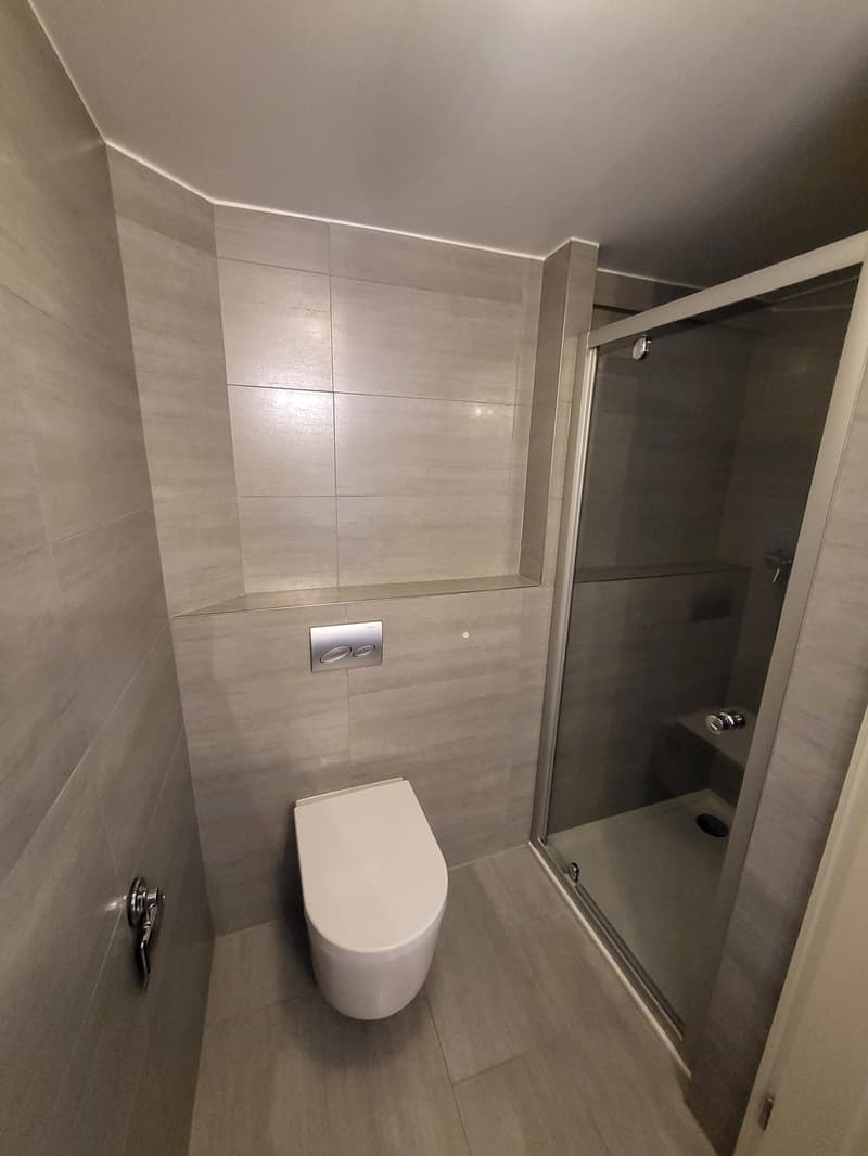 modern design, tile flooring, walk-in shower, toilet, silver fixtures, wall-mounted toilet