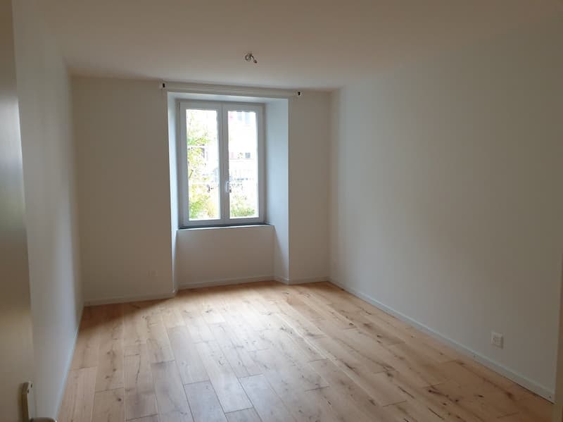 empty room, wooden floor, white walls, window, power outlets