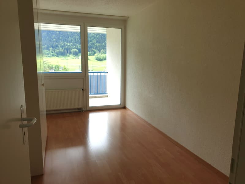 empty room, wooden floor, sliding glass door, balcony, white walls, white radiator, view of mountains