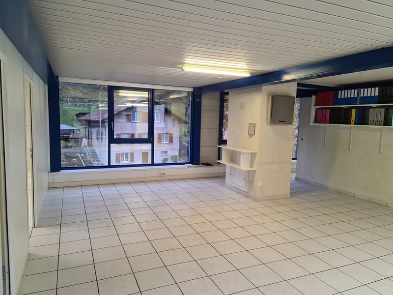 empty room, tile flooring, white walls, ceiling-mounted fluorescent light, windows with view, window sill with built-in cabinet, white wall-mounted cabinet, shelves with binders
