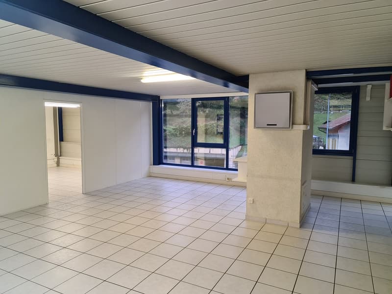 Empty room with white tile flooring, blue ceiling, windows with sills, an electrical panel, and a door leading to another room.