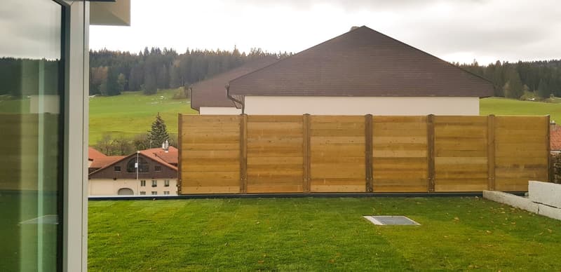 Wooden fence, green lawn, view of house, large yard