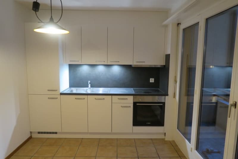 modern kitchen, white cabinets, black counters, sink, oven, dishwasher, washing machine