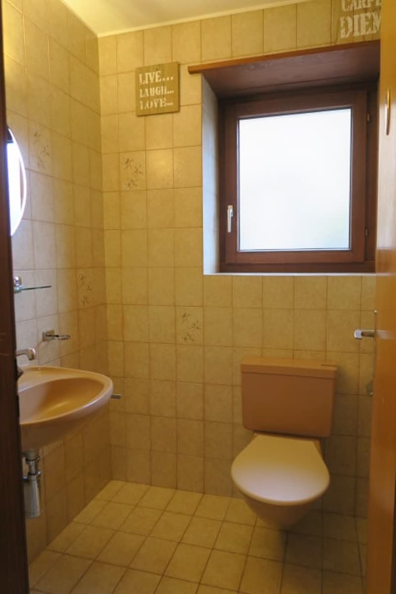 bathroom, beige tiles, white sink, toilet, window, faucet