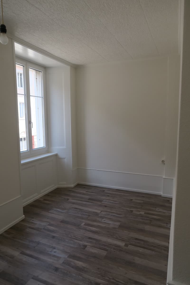 empty room, wooden floor, white walls, large window, white window sill