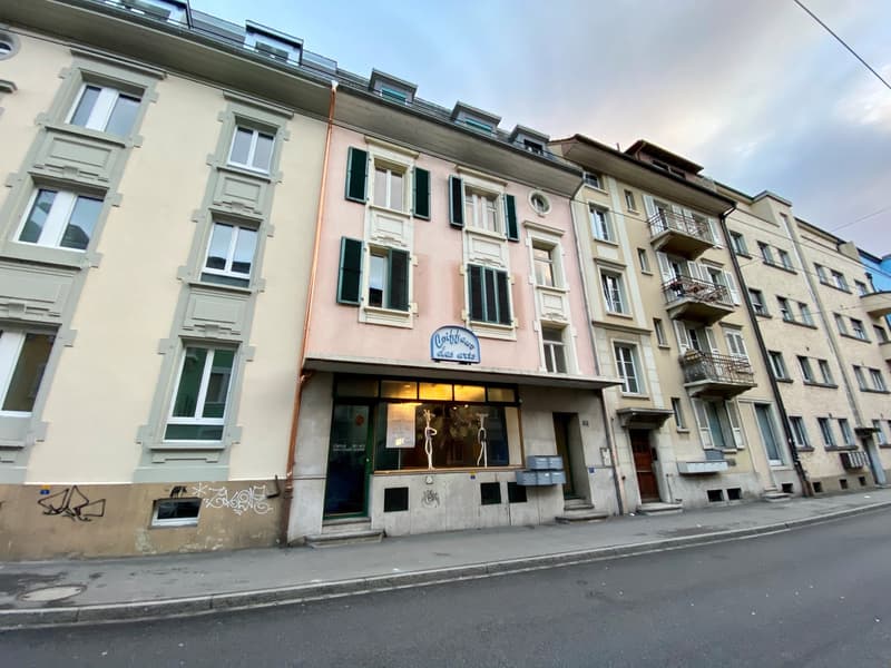Multi-story building with a mix of residential and commercial spaces, featuring a storefront with the name 'Confiserie des arts' displayed. The building has a traditional European architectural style with ornate windows, balconies, and a mix of light and