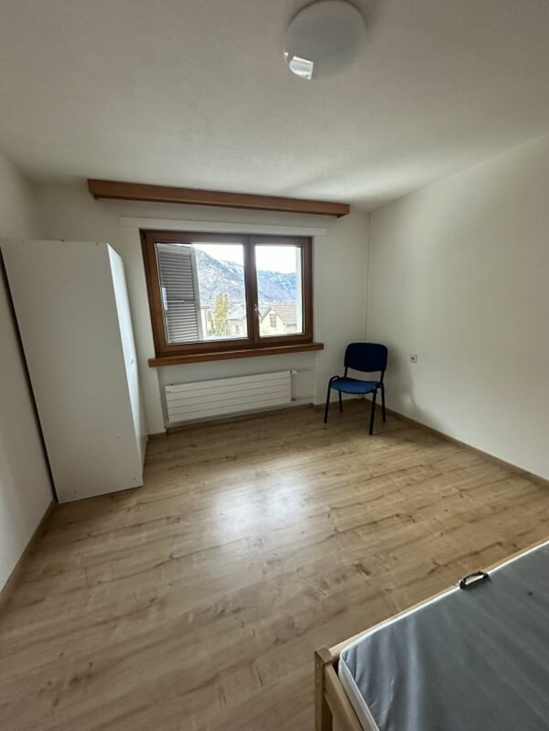 empty room, wooden floor, white walls, window, chair, wardrobe, heater