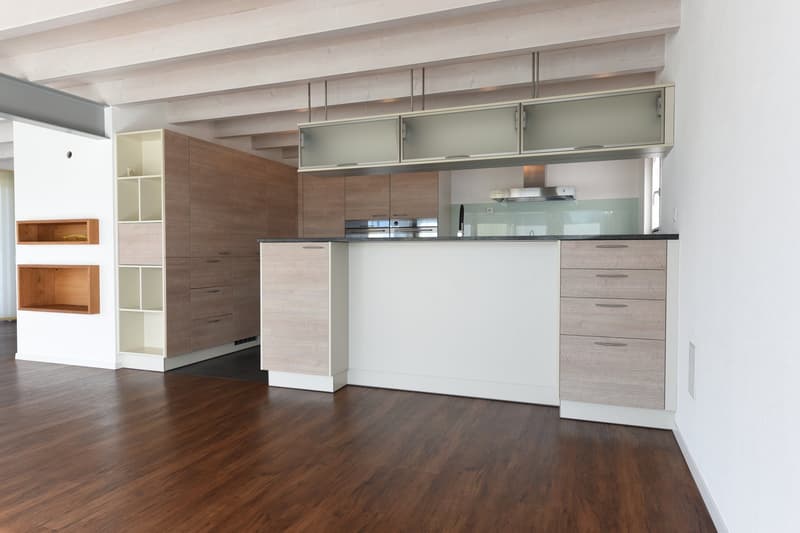 modern kitchen with wooden floors, white walls, wooden cabinets, glass cabinets, island countertop, stainless steel appliances