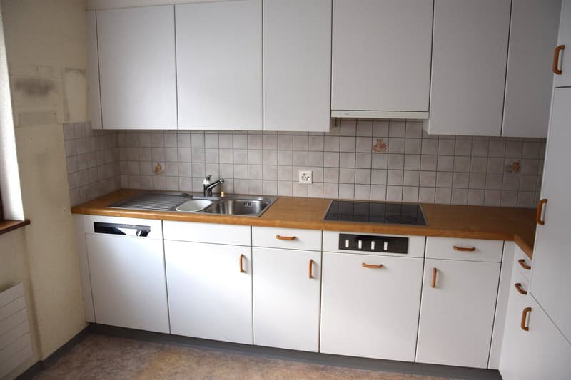modern kitchen with white cabinets, wooden countertops, stainless steel sink, dishwasher, electric stove
