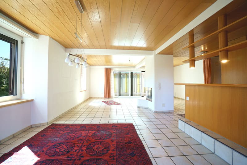 wide hallway with tile flooring, large red rug, sliding glass doors, window with sunlight