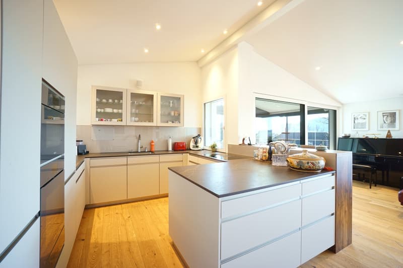 modern kitchen with white cabinets, wooden floor, island with granite countertop, large windows, appliances
