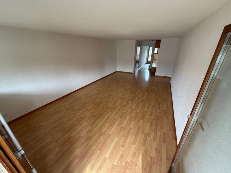 empty room with hardwood floors, white walls, open door