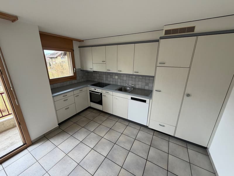 Fully equipped modern kitchen with integrated appliances, ceramic tiles, large window and balcony access