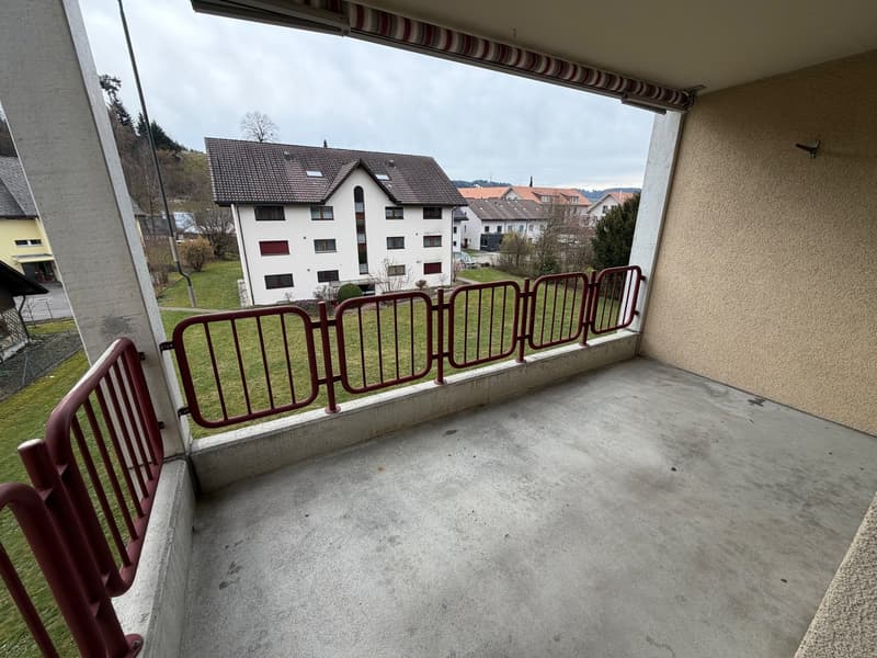 Outdoor balcony with red railing, empty, concrete floor