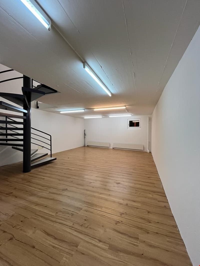 empty room, wooden floor, white walls, spiral staircase, radiators, window