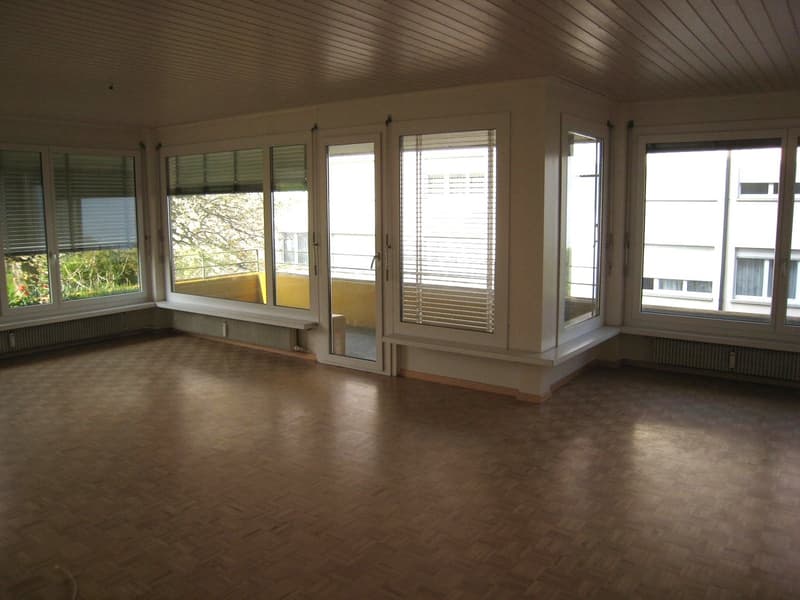 large room, wooden floor, large windows, sliding doors, benches, radiators