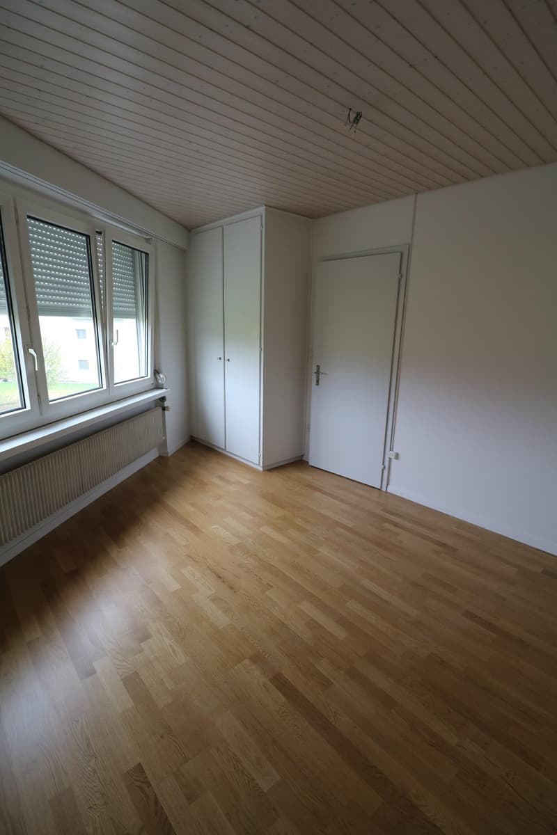 empty room, wooden floor, white walls, large window, white wardrobe, white door