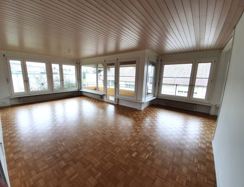 large room, wooden parquet floor, large windows, balcony