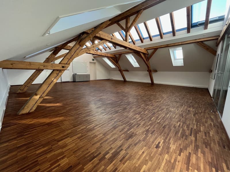 large open space, wooden beams, wooden floor, skylights, whiteboard, cabinet