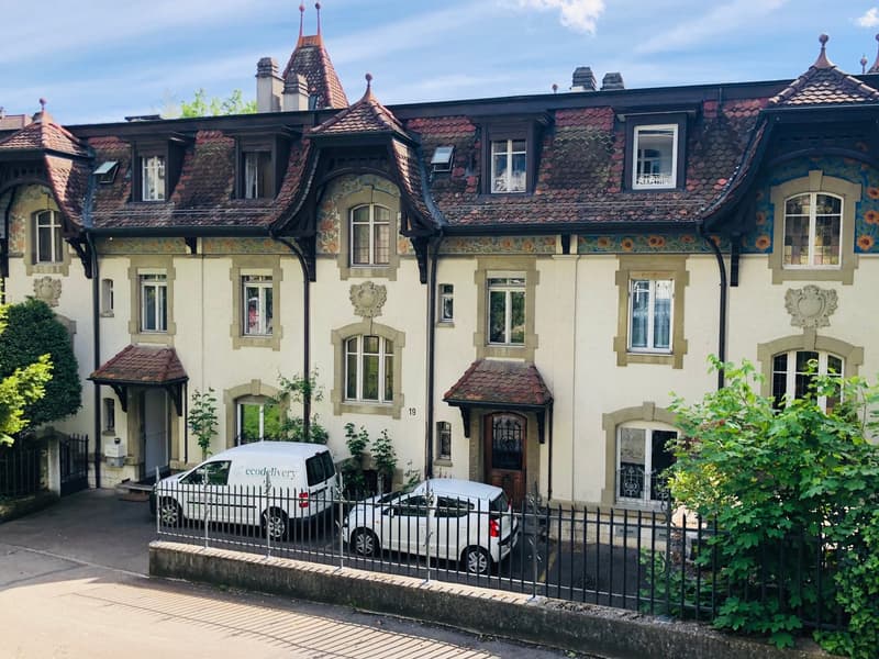 2 story house, ornate design, terracotta roof, balconies, front yard, cars parked