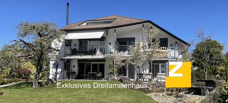 2 story house, white exterior, brown roof, large windows, balcony, garden, trees