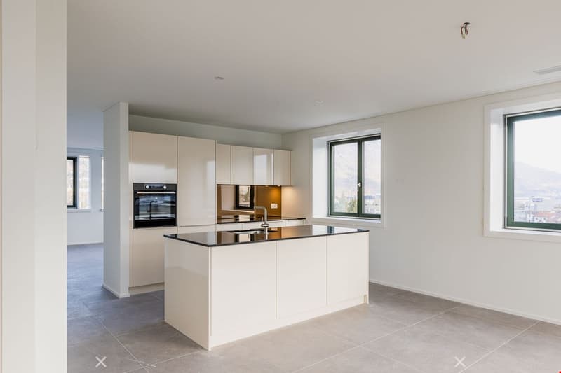 modern kitchen with island, white cabinetry, black countertops, large windows, modern appliances