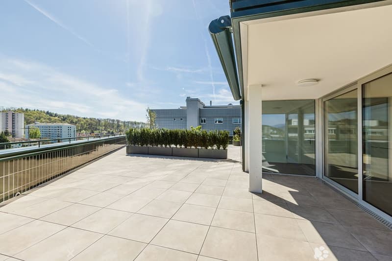 balcony with large floor tiles, modern building design, view of the hills and city buildings