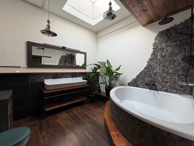 modern bathroom with wooden floor, white bathtub, double sink, mirror, plants, skylight