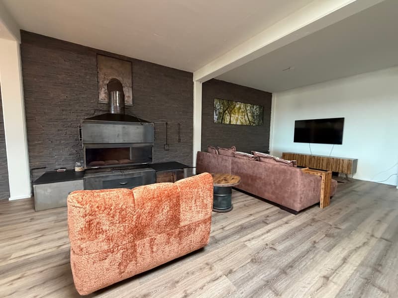 living room with fireplace, wooden floor, two couches, TV, wooden table