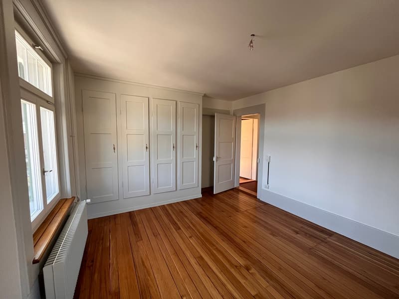 empty room, wooden floor, white walls, large windows, built-in wardrobes, radiator