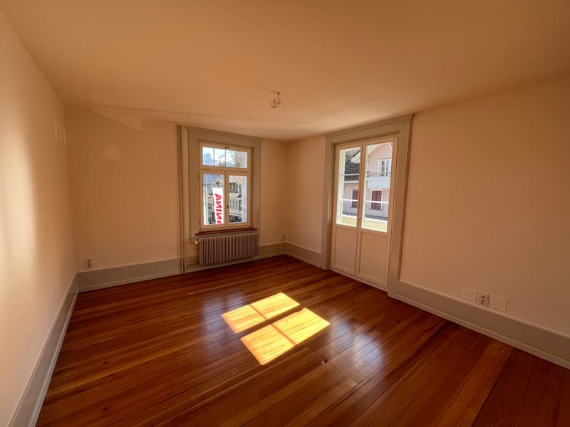 empty room, wooden floor, white walls, two windows, radiator, double doors