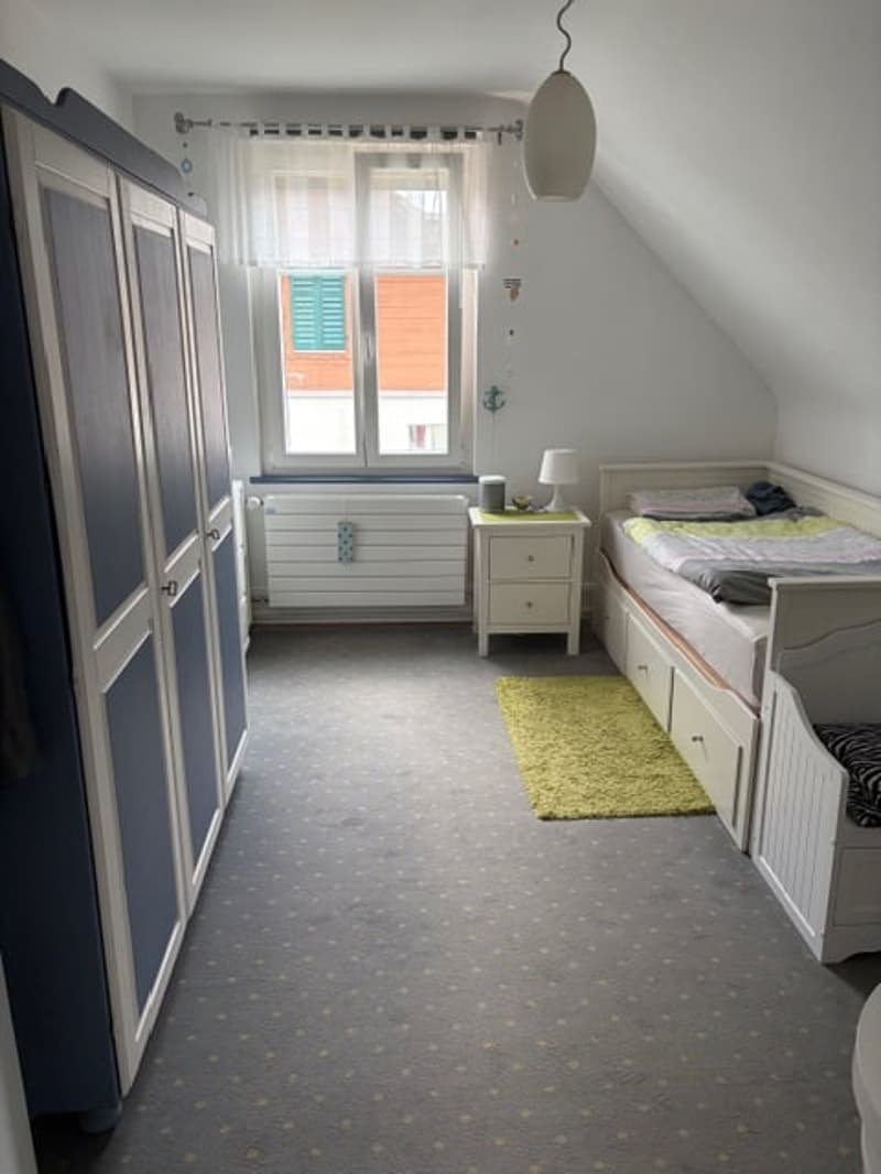 bedroom with bed, wardrobe, nightstand, lamp, rug, window, radiator