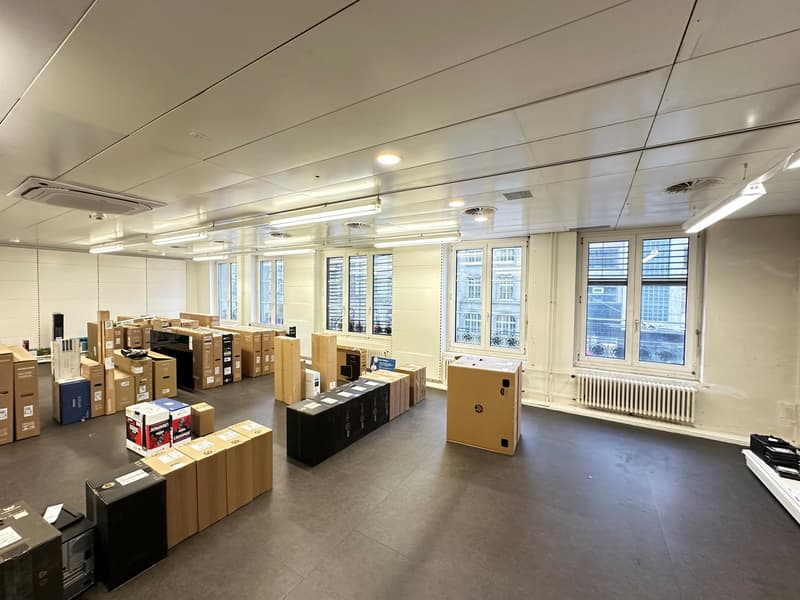 Empty room, boxes, radiator, fluorescent lights on ceiling, view of street outside