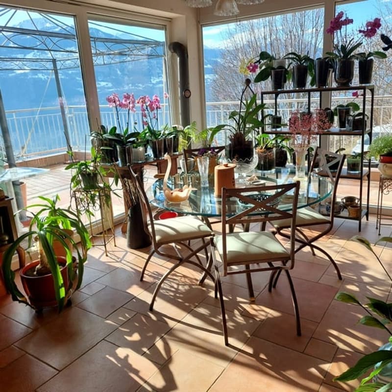 dining room with balcony, large windows, tiled floor, glass table, chairs, plants, mountain view