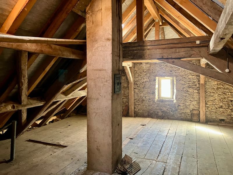 attic room, wooden beams, stone wall, wooden floor, small window