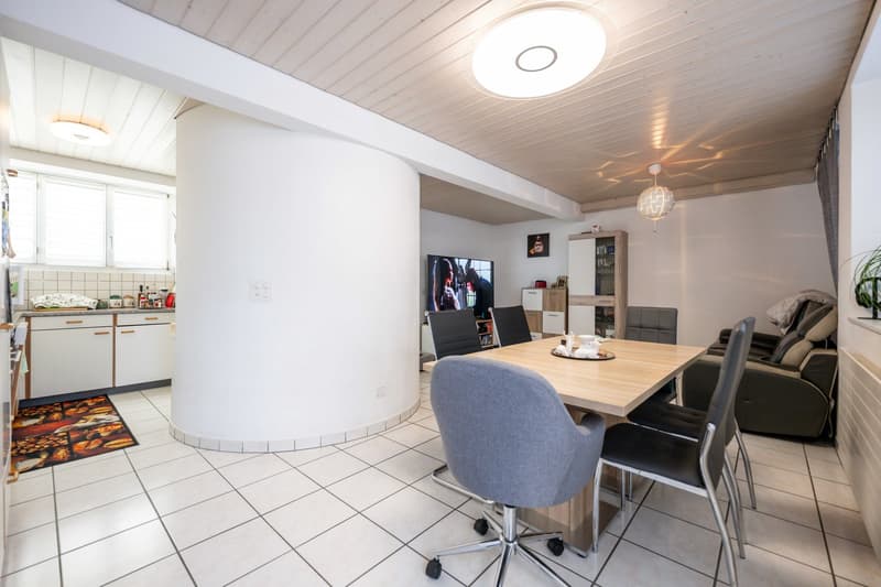 kitchen connected to living area, dining table, chairs, armchair, tv, round lights