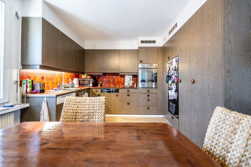modern kitchen, wooden cabinets, granite countertop, stainless steel appliances, under cabinet lighting, wine bottles on countertop