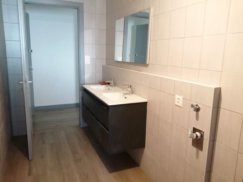 white tiles, mirror, double sink, black cabinet, wooden floor