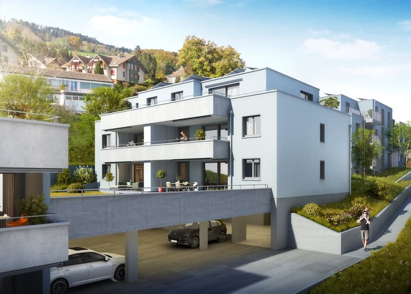 Modern apartment building with balconies, underground parking, and a car on the driveway