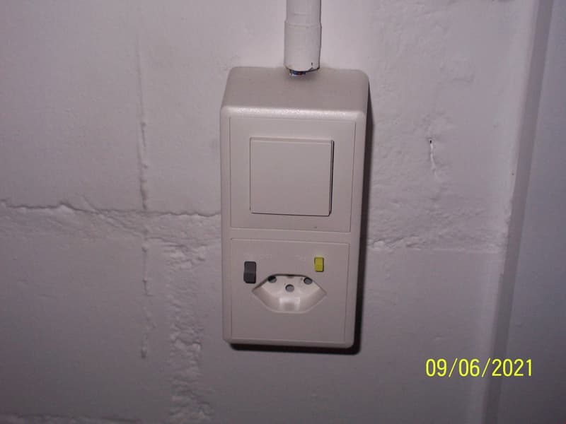 White electrical outlet with switch and socket, mounted on a white wall